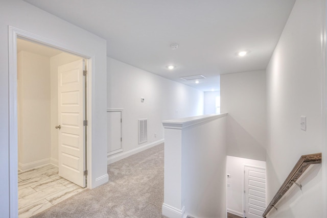 hall with visible vents, an upstairs landing, recessed lighting, baseboards, and light colored carpet