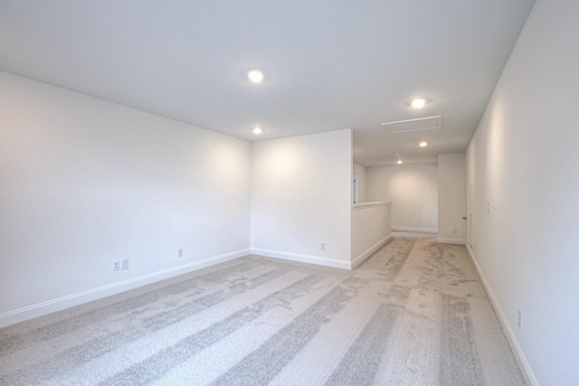 empty room with light colored carpet, attic access, recessed lighting, and baseboards