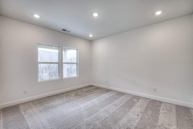 carpeted spare room featuring visible vents, recessed lighting, and baseboards