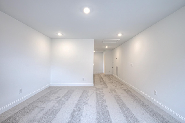 spare room with attic access, recessed lighting, baseboards, and light carpet