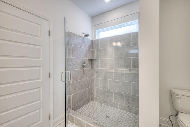 full bath with a shower stall, toilet, and baseboards