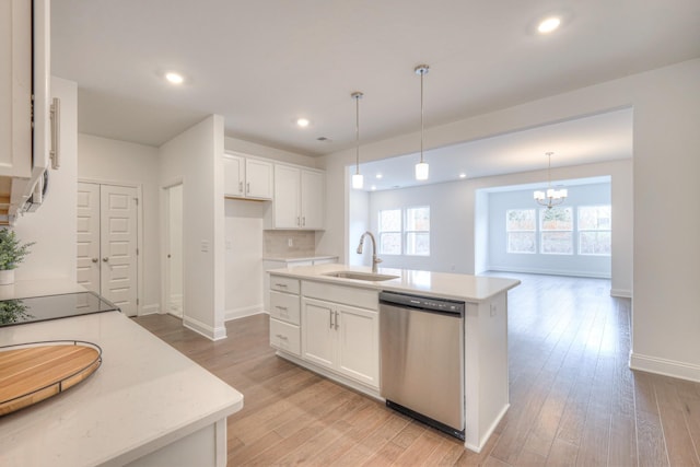 kitchen featuring light wood-type flooring, a sink, stainless steel dishwasher, white cabinetry, and light countertops