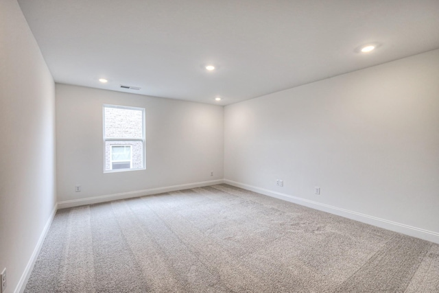 unfurnished room featuring recessed lighting, light colored carpet, visible vents, and baseboards