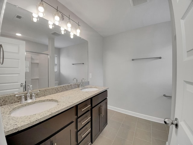 bathroom with a sink, visible vents, and a shower with door