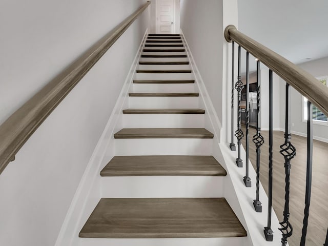 stairway with baseboards and wood finished floors