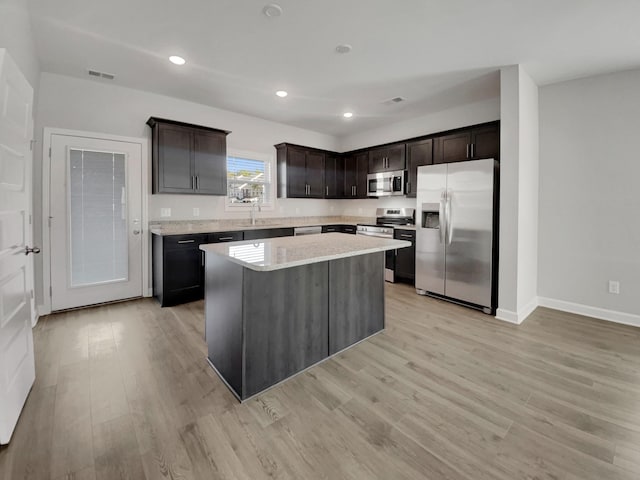 kitchen featuring a center island, recessed lighting, light wood-style floors, appliances with stainless steel finishes, and dark brown cabinetry