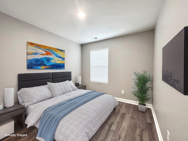 bedroom with visible vents, baseboards, and dark wood finished floors