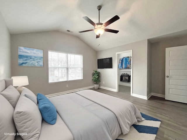 bedroom with visible vents, baseboards, lofted ceiling, wood finished floors, and a ceiling fan