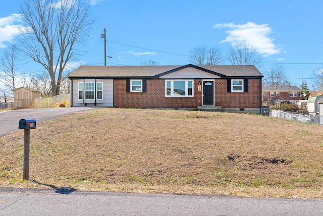 ranch-style house with fence, roof with shingles, a front lawn, aphalt driveway, and brick siding