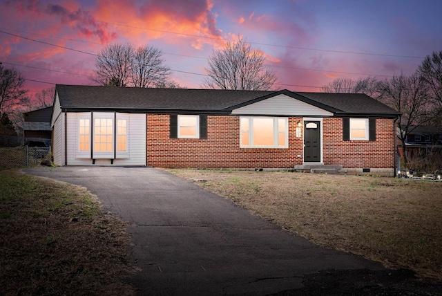 view of front of house with fence, a front lawn, crawl space, aphalt driveway, and brick siding