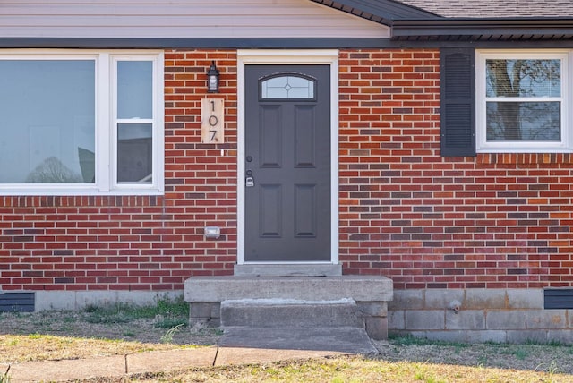 property entrance featuring brick siding