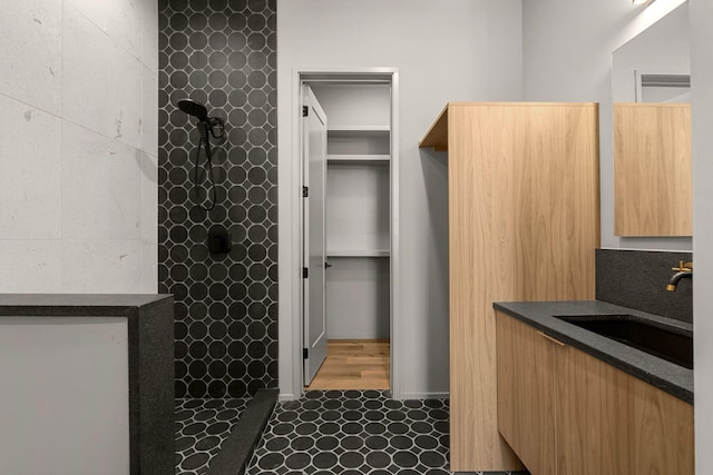 full bathroom featuring vanity and a tile shower