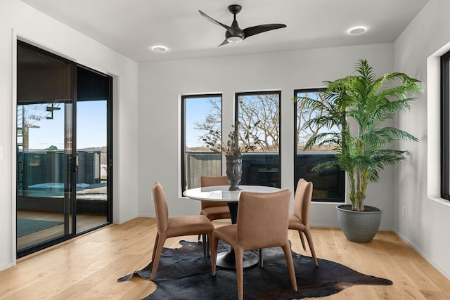 dining area featuring light wood-type flooring, baseboards, a healthy amount of sunlight, and a ceiling fan