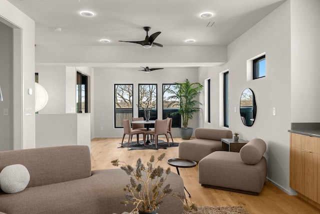 living area with ceiling fan and light wood-style flooring