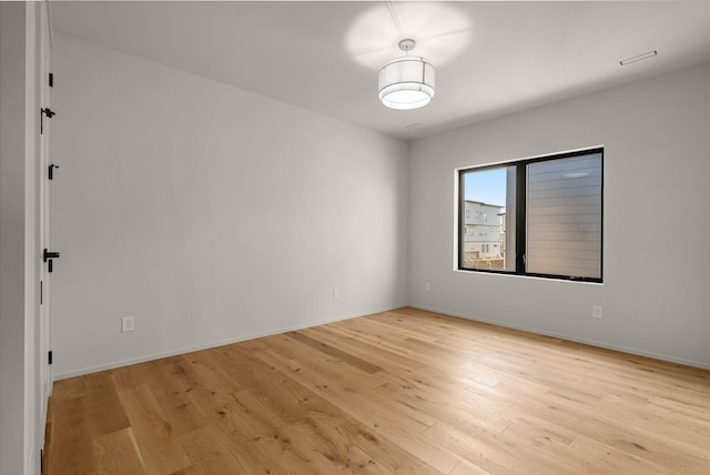 empty room featuring baseboards and light wood-style floors