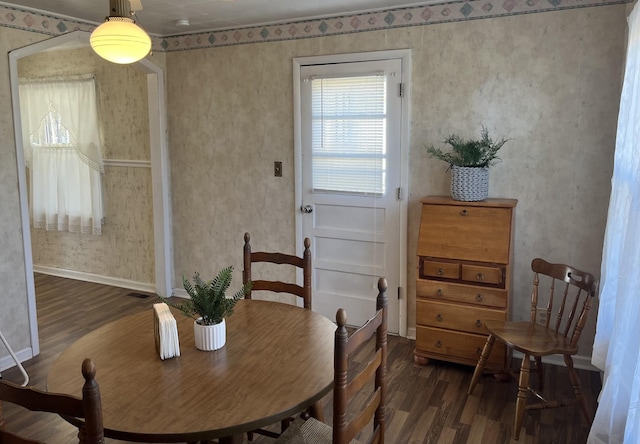 dining area featuring visible vents, baseboards, wood finished floors, and wallpapered walls