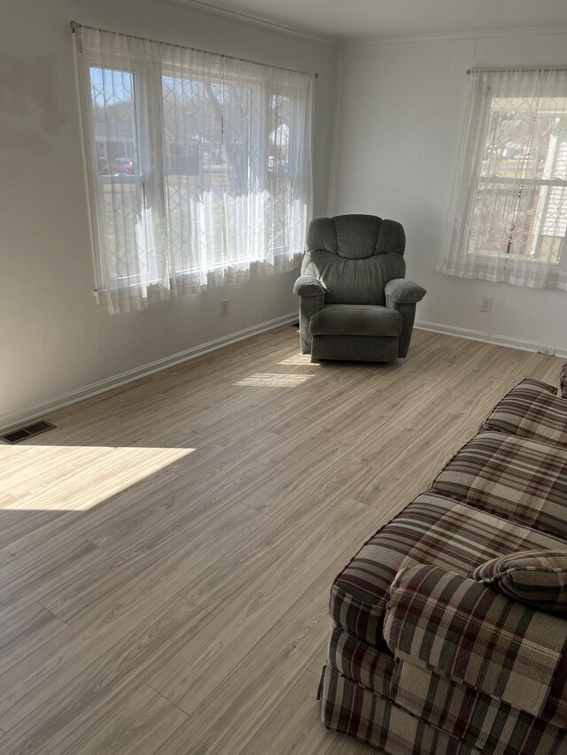 living area with visible vents, baseboards, and wood finished floors