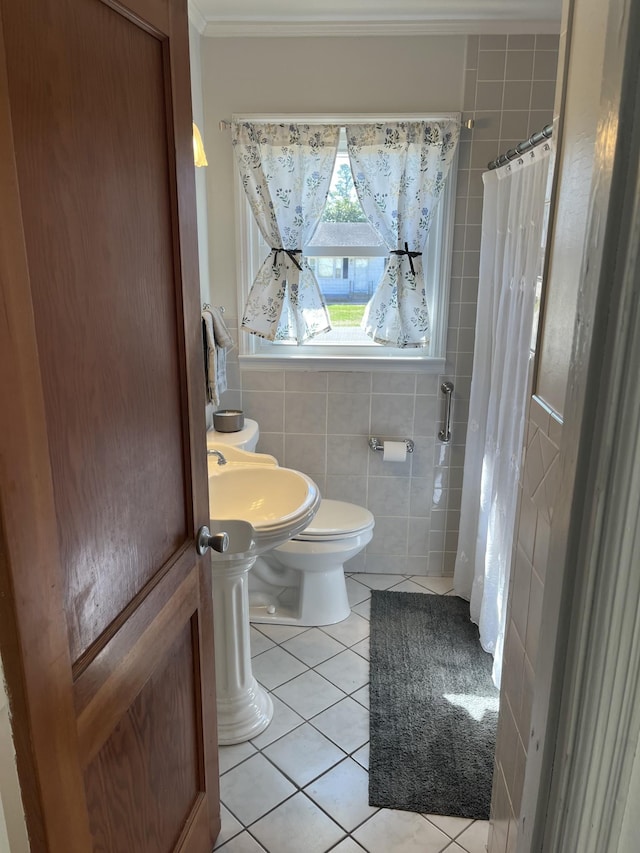 full bathroom featuring a shower with shower curtain, tile patterned flooring, crown molding, tile walls, and toilet