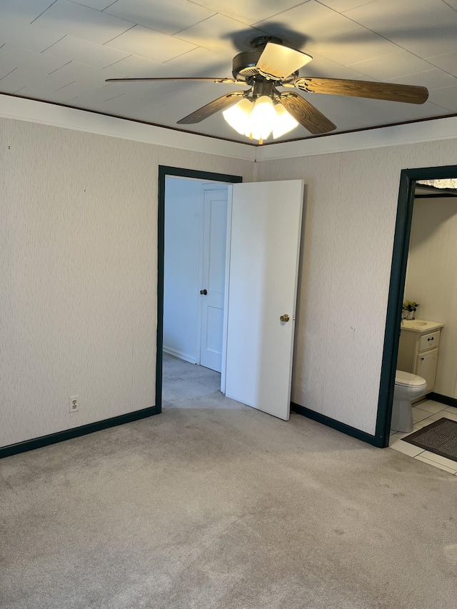 unfurnished bedroom with ceiling fan, crown molding, carpet, and a sink