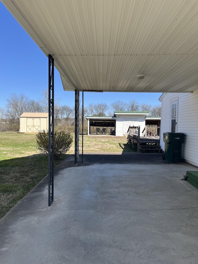 view of patio featuring a shed, an attached carport, and an outdoor structure