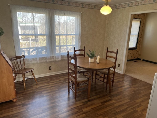 dining space featuring dark wood finished floors and baseboards