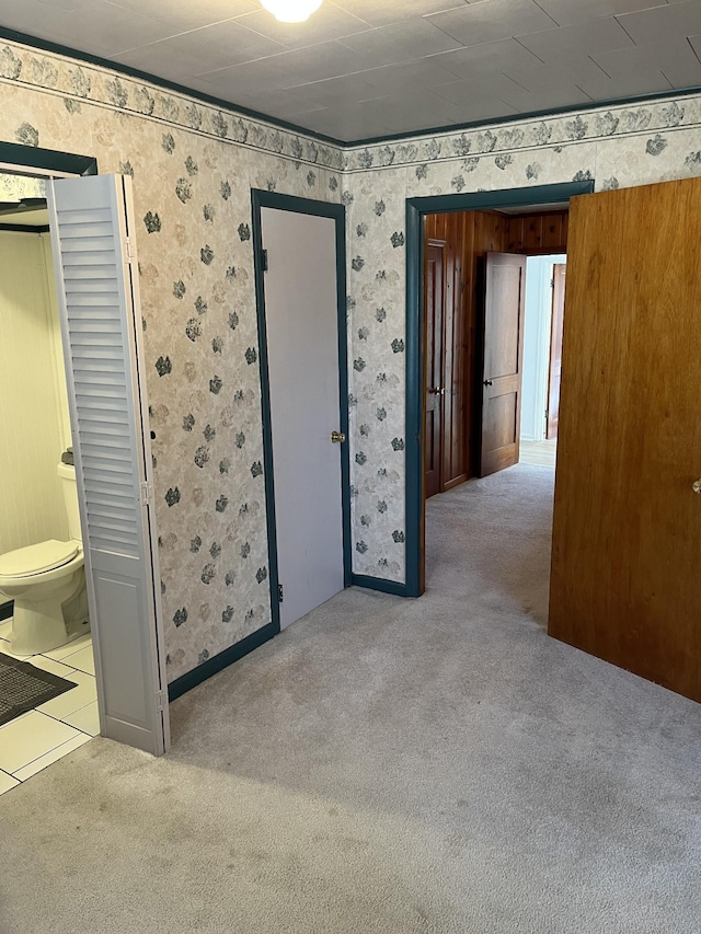 unfurnished bedroom with wallpapered walls and carpet floors