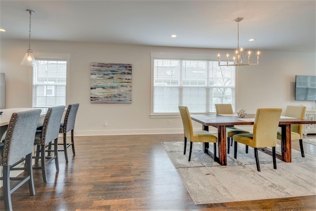 dining space with an inviting chandelier, plenty of natural light, wood finished floors, and baseboards