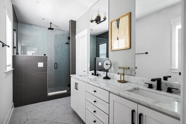 full bathroom featuring a sink, marble finish floor, a stall shower, and double vanity