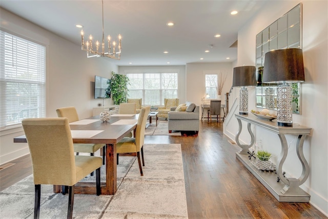 dining space with recessed lighting, baseboards, an inviting chandelier, and wood finished floors