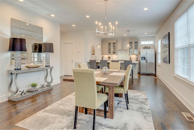 dining area with dark wood-style floors, recessed lighting, baseboards, and an inviting chandelier