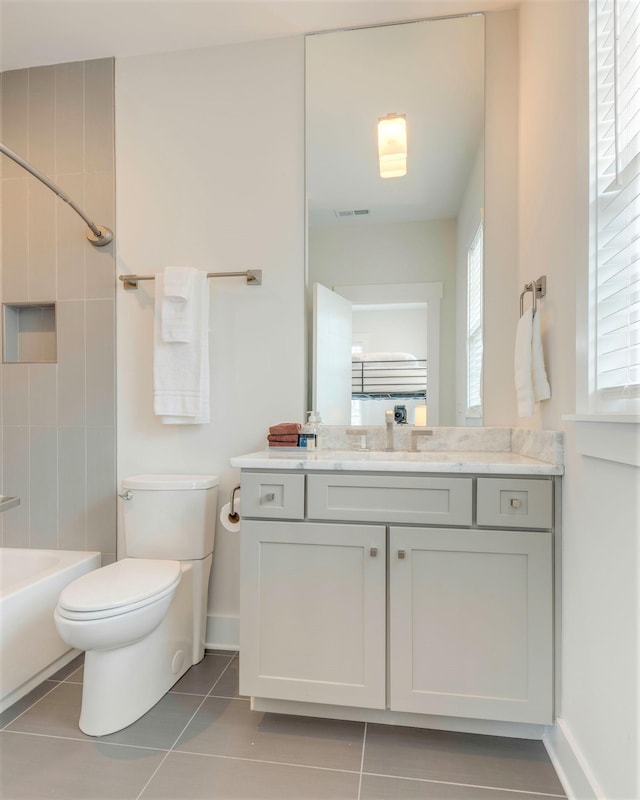 bathroom with vanity, baseboards, bathtub / shower combination, tile patterned floors, and toilet