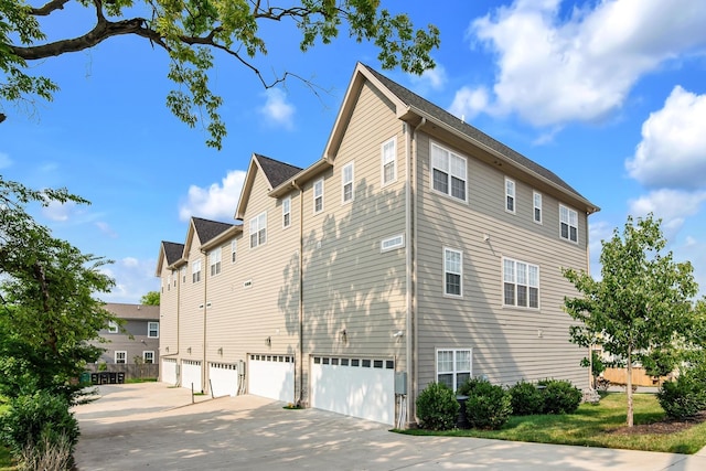 view of side of property with driveway and a garage