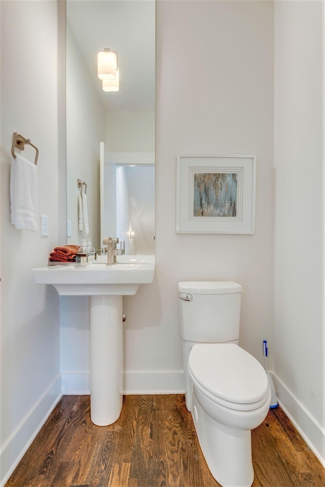 bathroom featuring toilet, baseboards, and wood finished floors