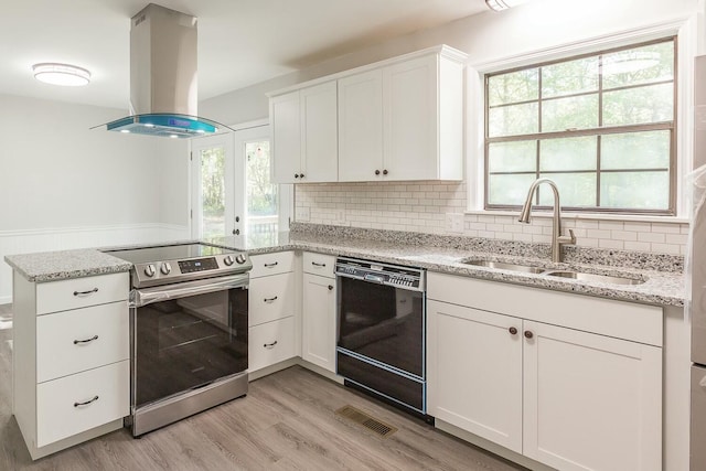 kitchen with dishwasher, a peninsula, island range hood, electric range, and a sink