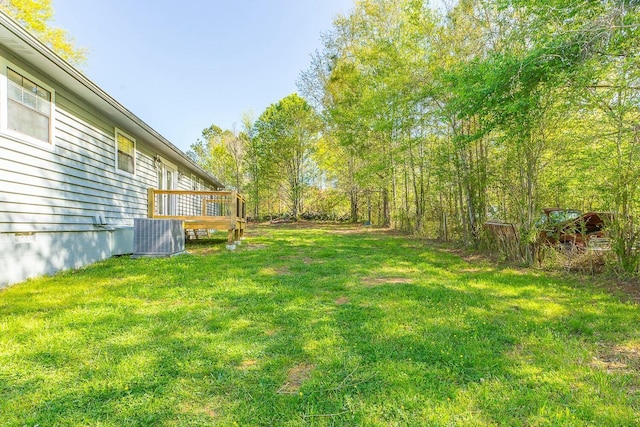 view of yard featuring central air condition unit and a wooden deck