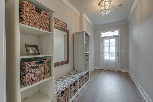 mudroom with visible vents, wood finished floors, crown molding, baseboards, and a chandelier