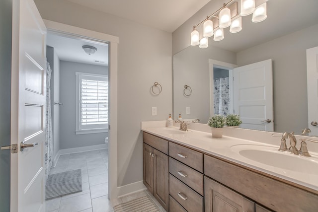 full bath with a sink, toilet, double vanity, and tile patterned flooring