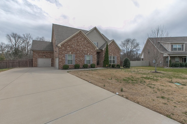 view of front of house with brick siding, concrete driveway, an attached garage, and fence