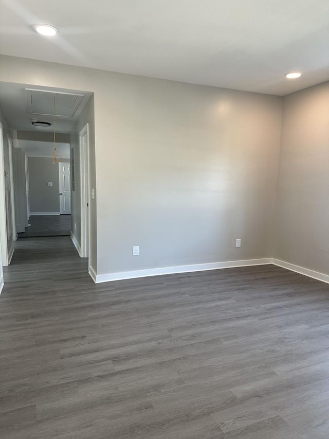 spare room with attic access, recessed lighting, dark wood-style floors, and baseboards