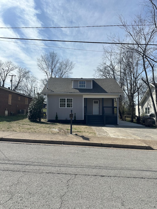 bungalow with board and batten siding and a shingled roof