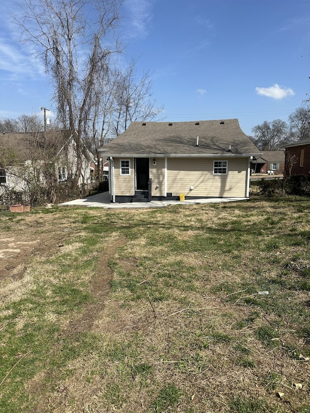 back of property with a patio area and a lawn