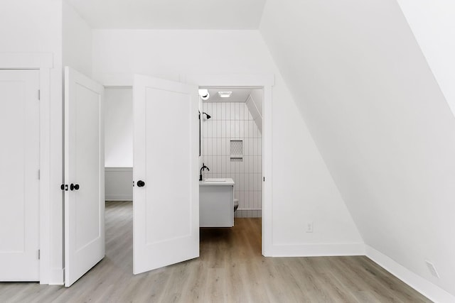 unfurnished bedroom with light wood-style floors, baseboards, and a sink