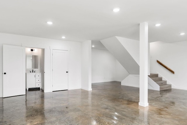 additional living space featuring a sink, recessed lighting, finished concrete flooring, and stairs