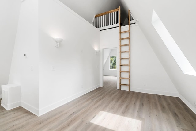 bonus room with a skylight, baseboards, and wood finished floors