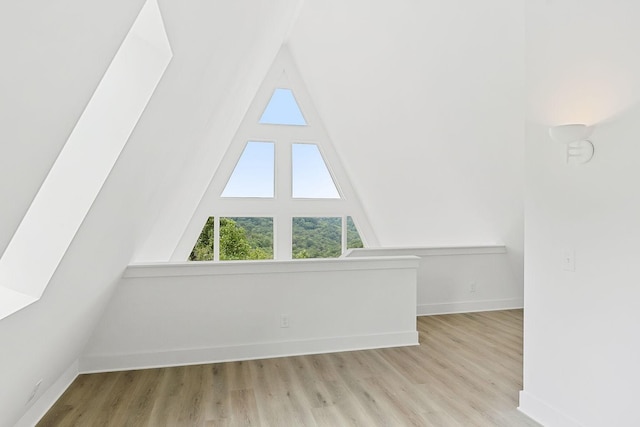 bonus room featuring vaulted ceiling, wood finished floors, and baseboards