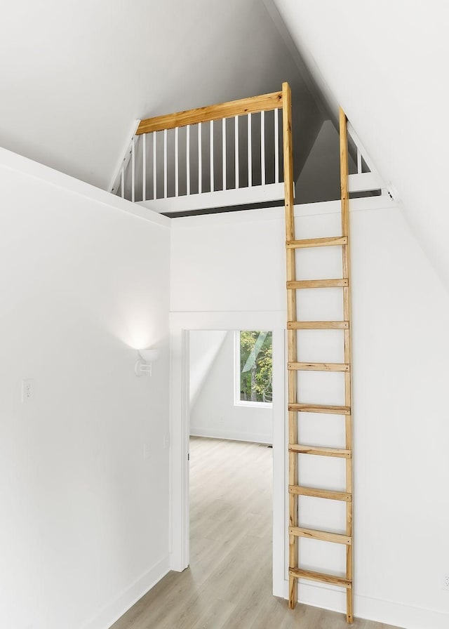 additional living space with lofted ceiling, wood finished floors, and baseboards