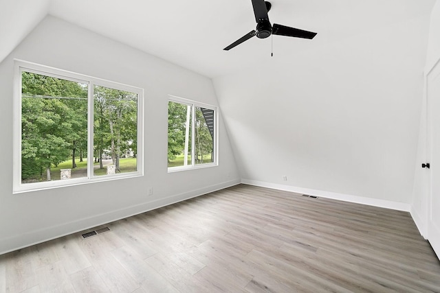 additional living space featuring visible vents, lofted ceiling, and wood finished floors