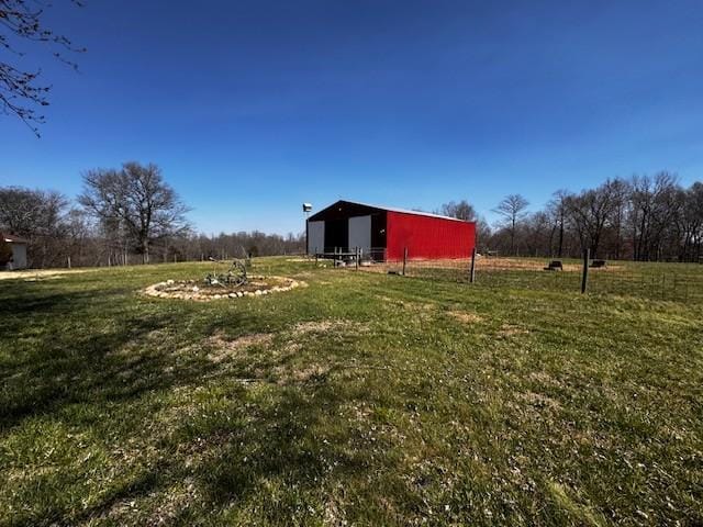 view of yard featuring an outdoor structure, a rural view, and a pole building