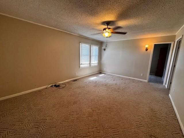 unfurnished room featuring crown molding, baseboards, carpet flooring, a textured ceiling, and a ceiling fan