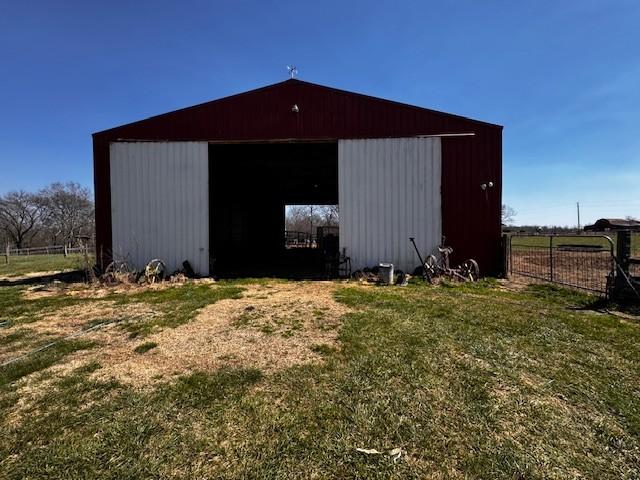 view of pole building featuring a yard and fence